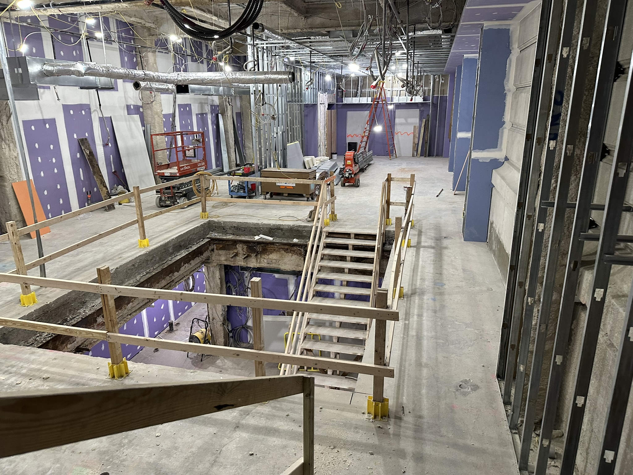 Wide view of Bellevue Bathhouse renovation interior with temporary guardrails and active construction.